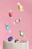 Sweets falling into a paper bag