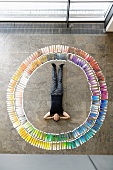Business man lying in circle of colour cards