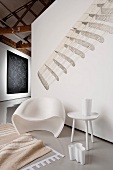 Raumecke mit Retro-Stuhl, Beistelltisch, Schirmständer und Teppich auf grauem Kunstoffboden, Wandgrafik und Wandteppich