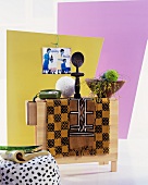 Ethnic fabrics and African sculpture next to dish and ornaments on folded table in front of brightly coloured partitions