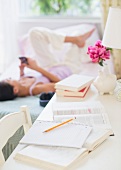 Woman using telephone on bed behind desk