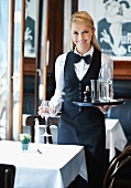 A waitress setting out glasses at a pub