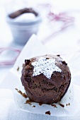 A nut and date muffin topped with an icing sugar star