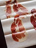 Thin Slices of Spanish Pata Negra Ham on Parchment Paper