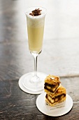 A Milkshake in a Champagne Flute with Small Chocolate Nut Sandwich Squares
