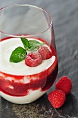 Two glasses with yogurt - quark creme with razberries as dessert, selective focus