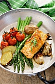 Baked vegetables and salmon in a pan