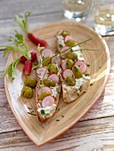 Slices of bread topped with olives and radish slices