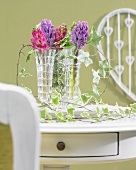 Hyacinth posies in crystal vases with tendrils of ivy leaves