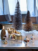 Weihnachtsdeko zum Aufhängen und vergoldeter Miniatur Chaiselongue vor Deko Tannenbäumchen