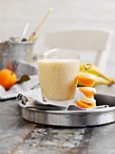 Apricot, banana and mandarin shake with a fruit skewer