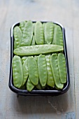 Mange tout in a plastic container