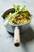 Minestrone soup with celery in a saucepan