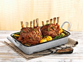 Racks of lamb with potatoes and green beans in a roasting tin