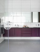 Long washstand counter and strip of mirrors on white wall tiles