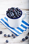Lots of blueberries in an enamel mug