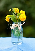 Small Jar of Yellow Lantana Flowers Toe with Twine on an Outdoor Table