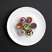 Assorted hand-made filled chocolates on a plate (view from above)
