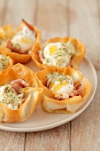 Filo pastry cases filled with prosciutto, quail's eggs and hollandaise sauce