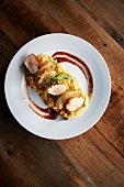 Chicken skin wrapped scallops over grits with fennel and kimchi sauce