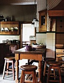Rustic wooden table and stool in a country kitchen with white wall tiles