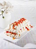 Meringue cake with strawberries and passion fruit sauce