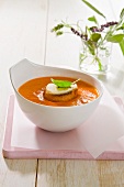 Tomato soup topped with a sliced of toasted bread and mozzarella