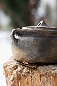 A rustic clay pot with lid