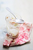 The remnants of tiramisu in a glass, with a spoon