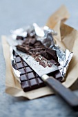 A bar of chocolate, partly chopped, in silver foil