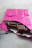 A broken chocolate bar in pink foil