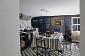 Rustic kitchen with blackboard, wooden door, dining table and chairs
