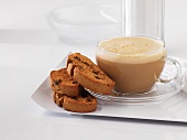 A cup of caffe latte with biscotti