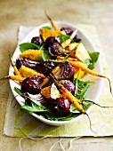 Warm root vegetable salad made with carrots, pumpkin, beetroot and onions