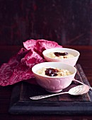 Two bowls of creamy rice pudding with strawberry jam and cinnamon