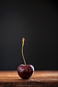 A cherry on a wooden table