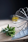 Fresh rosemary, an egg whisk and a knife