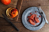 Blood Orange Segments on a Metal Plate with a Fork; From Above