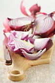 Red onions, partly sliced, on a chopping board