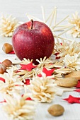 Christmas decorations with an apple, nuts and straw stars