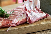 Raw pork ribs with thyme on a wooden board