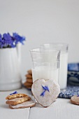Milk with heart-shaped cinnamon biscuits with sugar glaze and cornflower petals