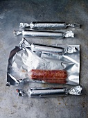 Curry-spiced sausages wrapped in tin foil