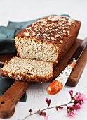Gluten Free Seeded Honey Bread; Partially Sliced on a Cutting Board