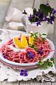 Beetroot pasta with a boiled egg, herb quark and violet flowers