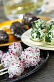 Three types of cheese in balls: with radishes, with herbs and with black olives