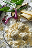 Bratfertige Gemüsebällchen in einer Mischung aus Brotkrümel und geriebenem Käse gewendet