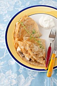 Banana Stuffed Crepes on a Plate with Fork and Knife
