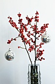Discokugeln mit Spiegelmosaik an weihnachtlichen Stechpalmenzweigen mit roten Beeren