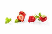 Strawberries with leaves, whole and halved